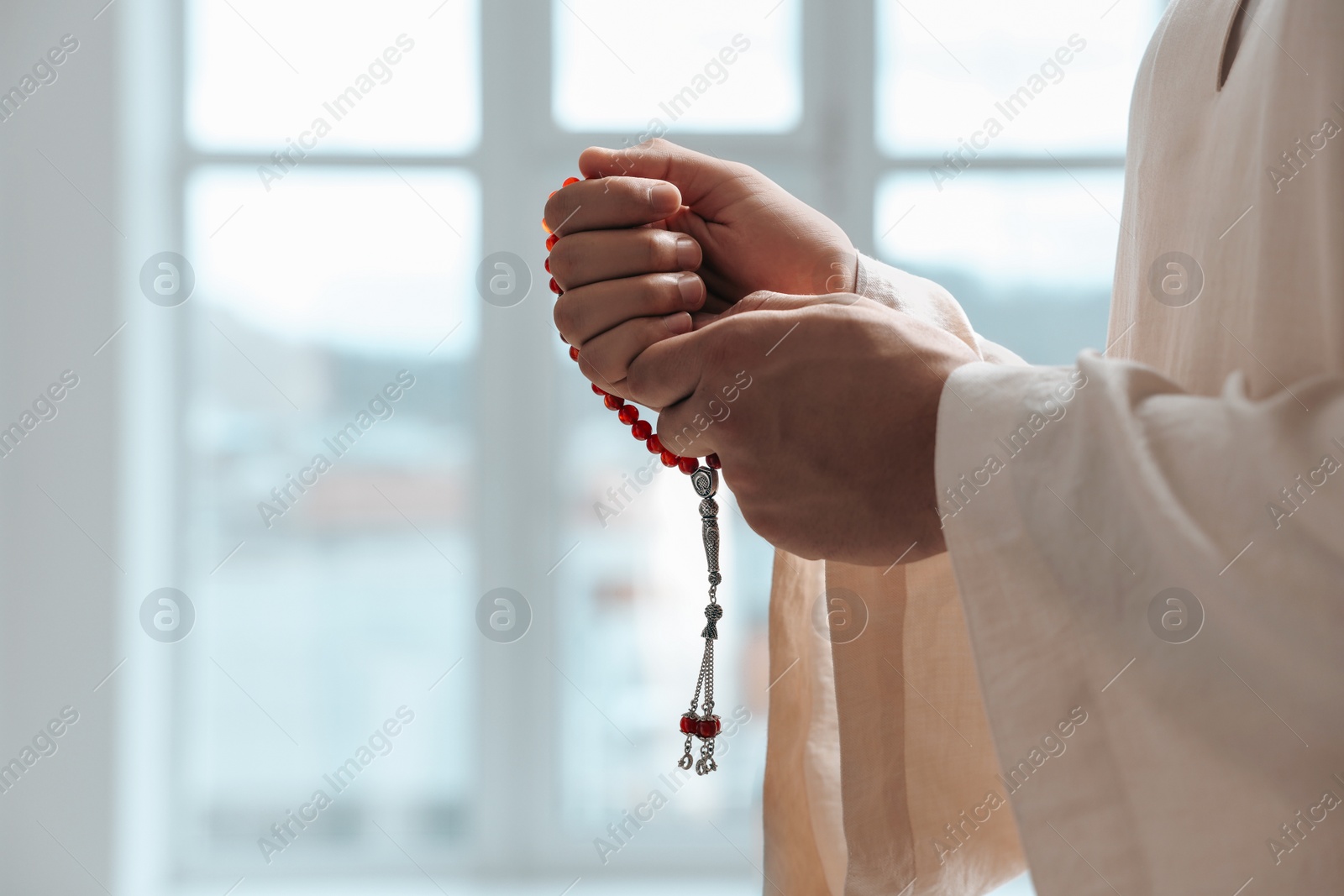 Photo of Muslim man with misbaha indoors, closeup. Space for text