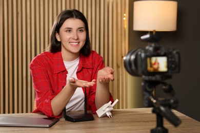 Photo of Smiling technology blogger recording video review about WI-FI devices at home