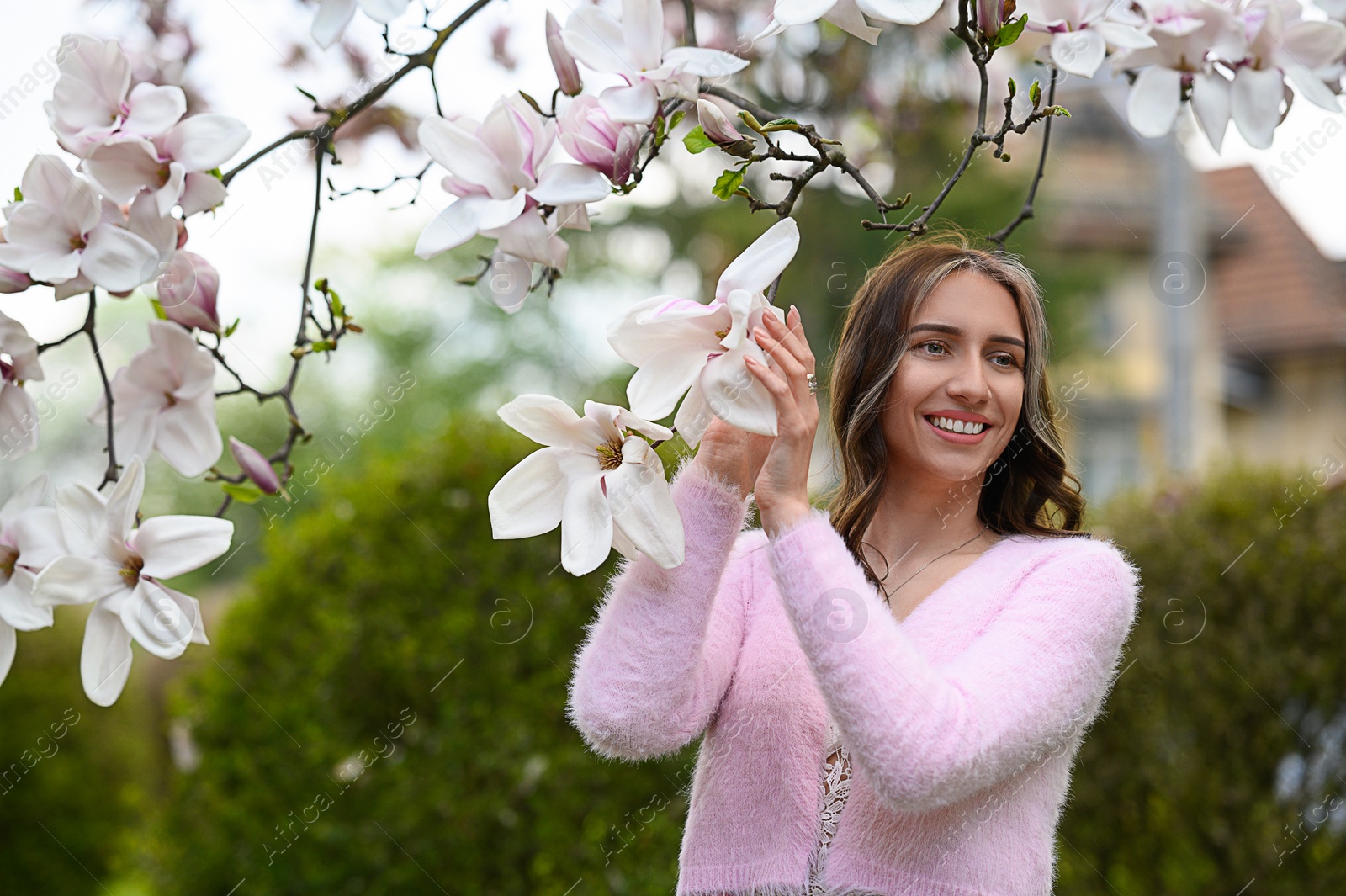 Photo of Beautiful young woman near blossoming magnolia tree on spring day