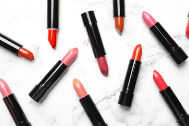 Different lipsticks on marble background, flat lay