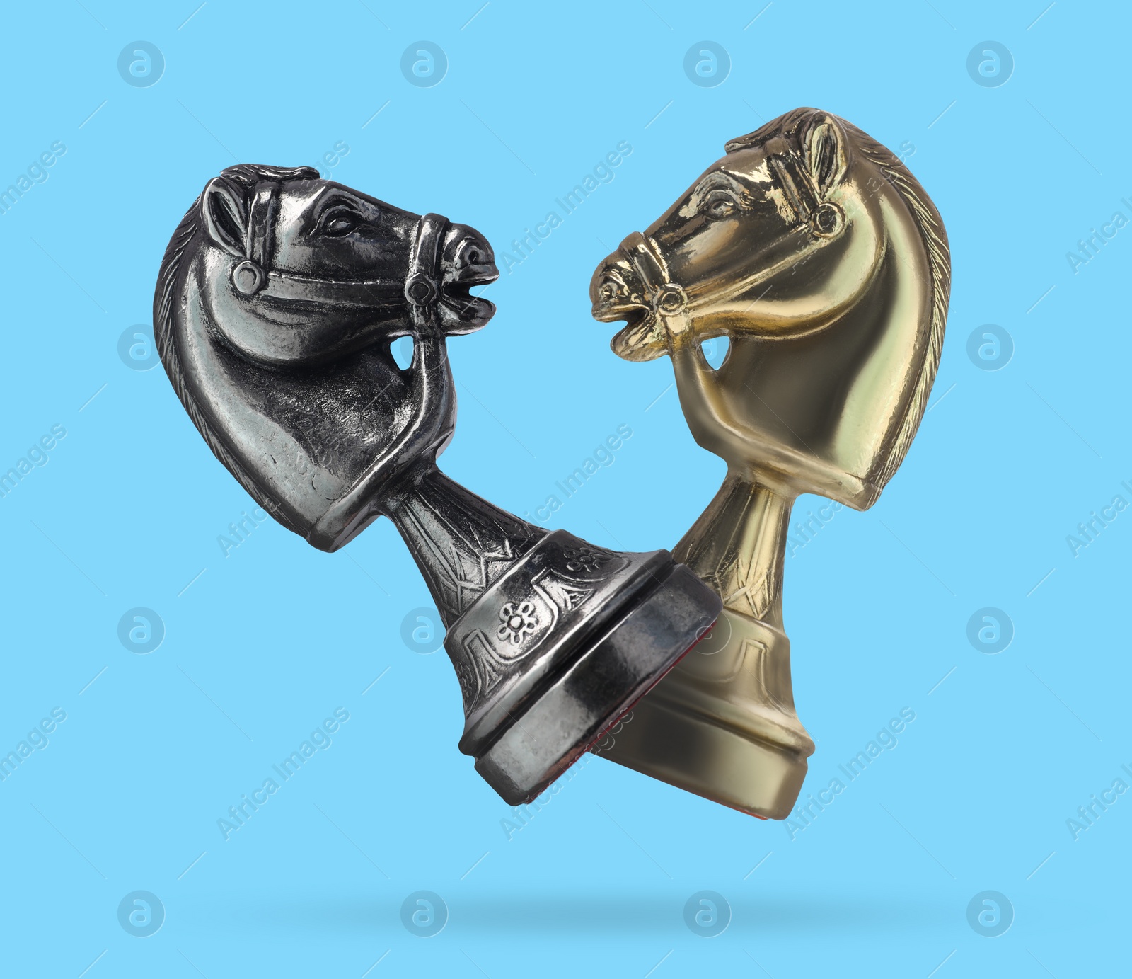 Image of Chess knights in air on light blue background