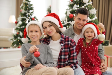 Happy family with cute children near Christmas tree together at home