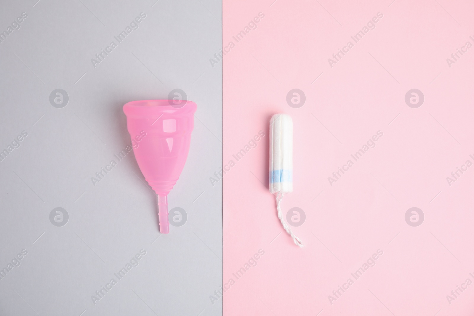 Photo of Menstrual cup and tampon on color background, flat lay