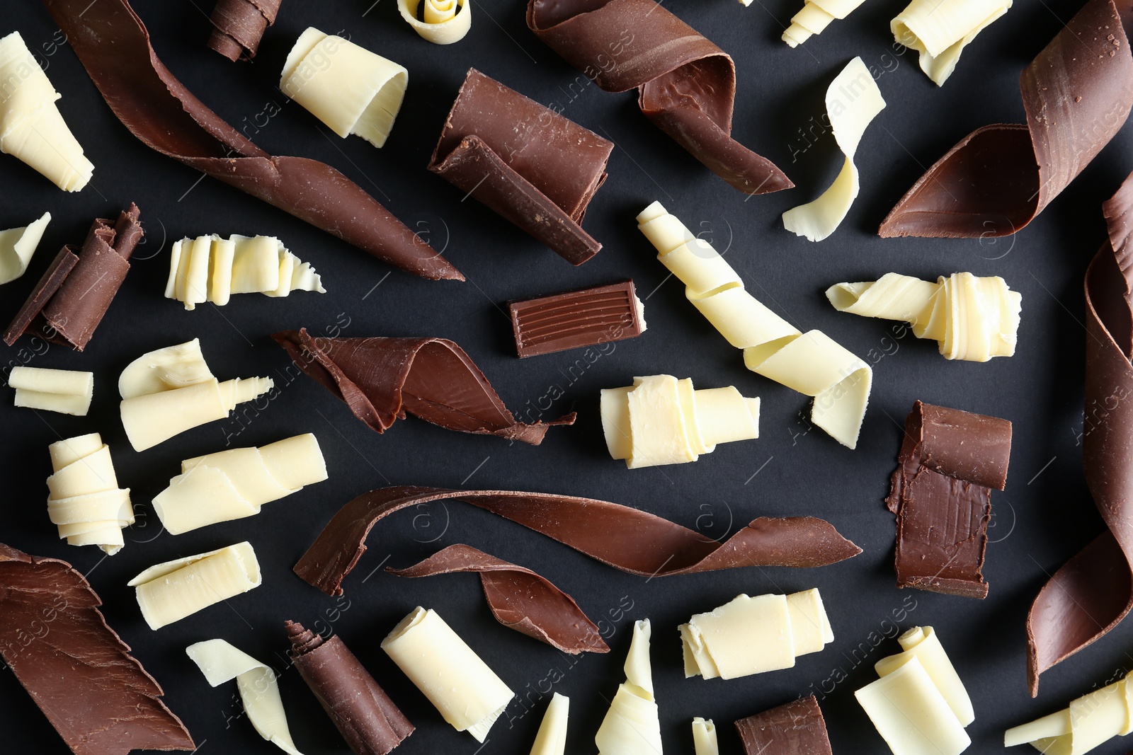 Photo of Yummy chocolate curls on black background, top view