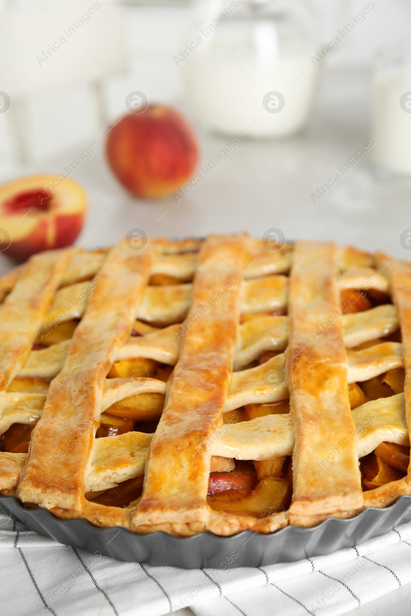Photo of Delicious fresh peach pie on light kitchen table, closeup