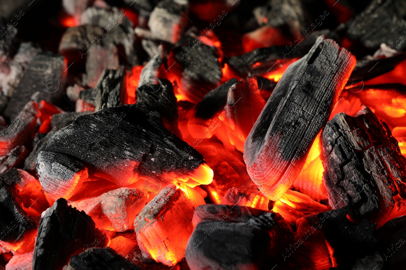 Photo of Pieces of hot smoldering coal as background, closeup