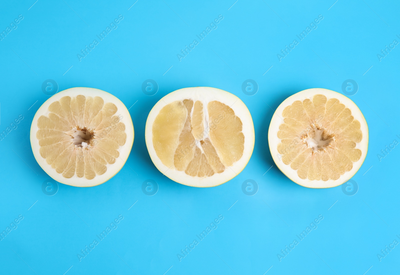 Photo of Fresh cut pomelo fruits on blue background, flat lay