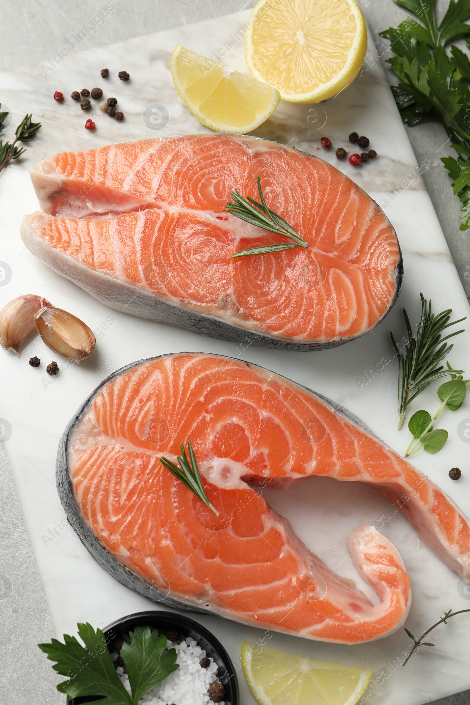Photo of Fresh salmon and ingredients for marinade on light grey table, top view