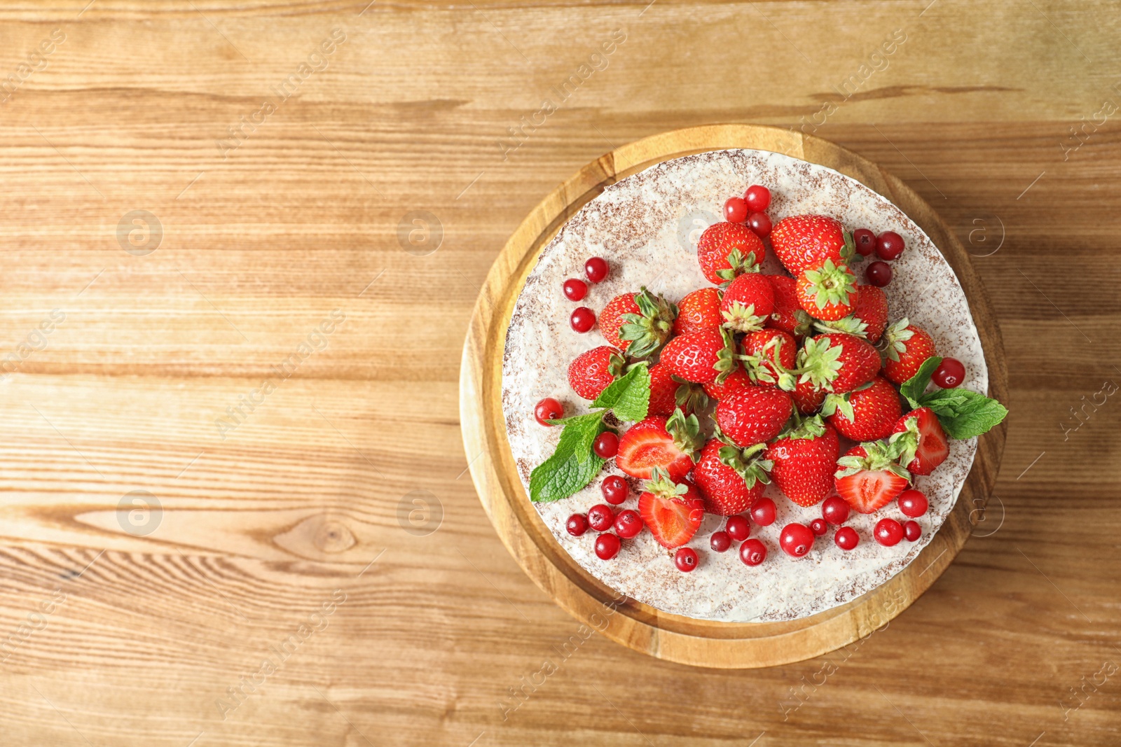 Photo of Delicious homemade cake with fresh berries and space for text on wooden table, top view