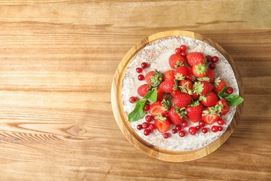 Photo of Delicious homemade cake with fresh berries and space for text on wooden table, top view