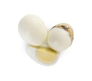 Peeled hard boiled quail eggs and another one partly in shell on white background, top view