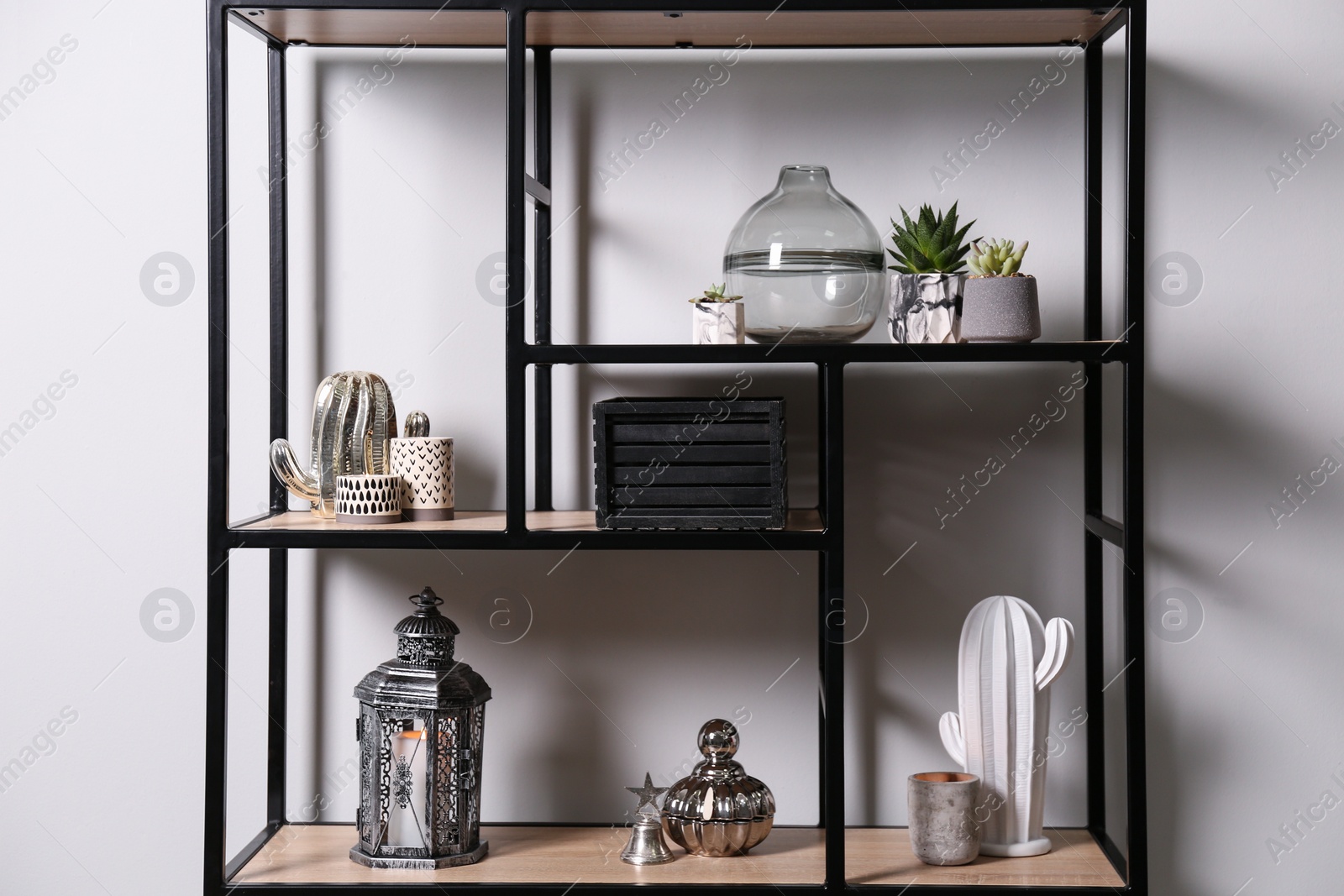 Photo of Shelving with different decor and houseplants near white wall. Interior design