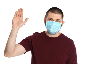 Photo of Man in protective mask showing stop gesture on white background. Prevent spreading of coronavirus