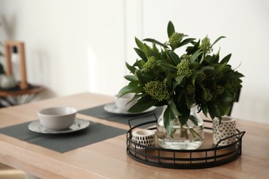 Photo of Fresh bouquet on dining table in room, closeup. Interior design
