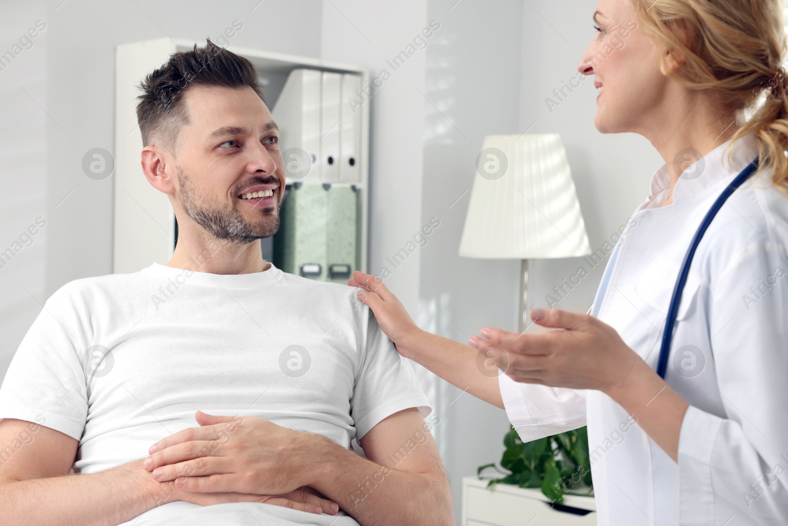 Photo of Doctor with stethoscope consulting patient in clinic