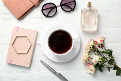 Flat lay composition with cup of coffee and stylish accessories on light background