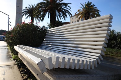 Photo of White wooden bench on city street, closeup