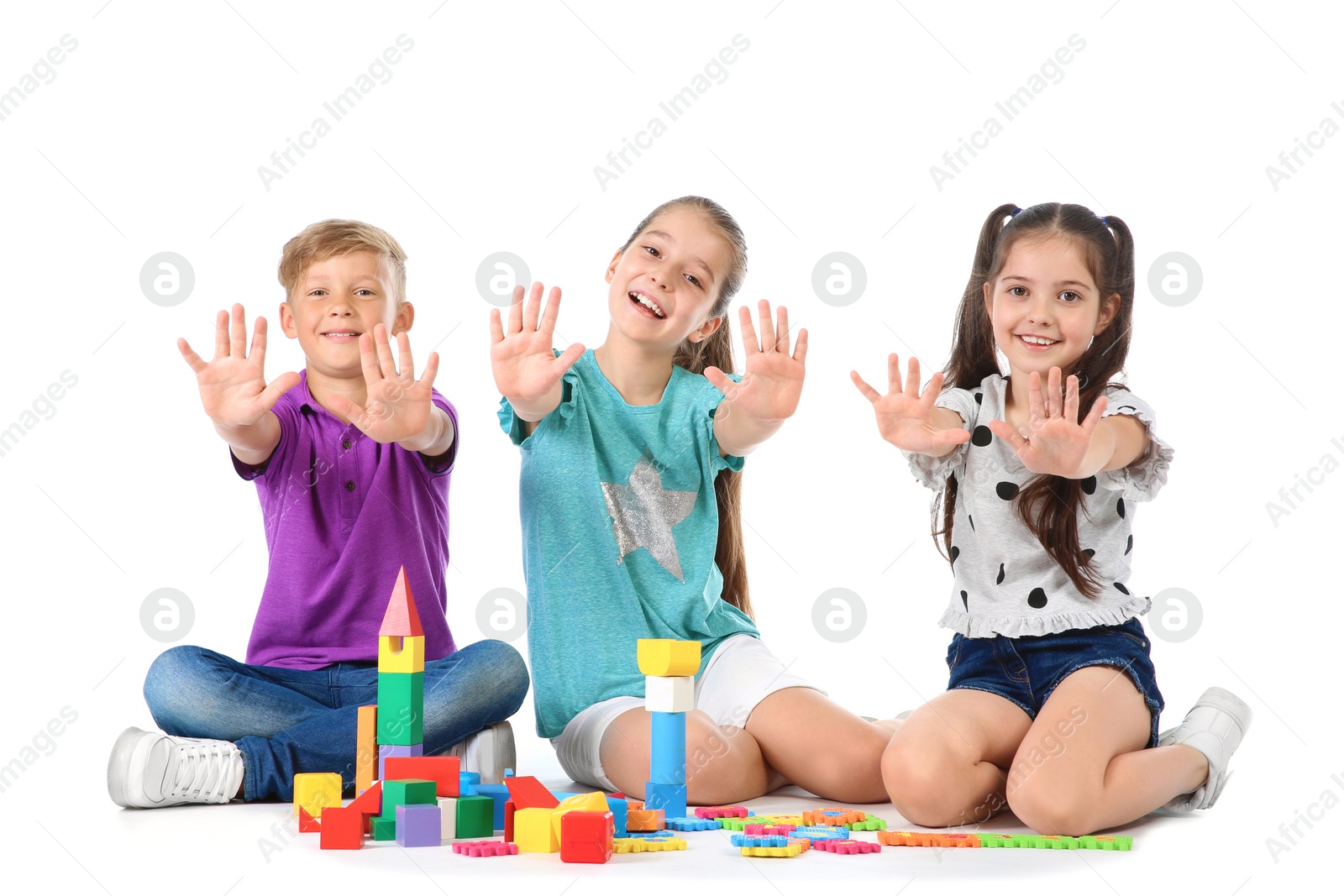 Photo of Little children playing together on white background. Indoor entertainment