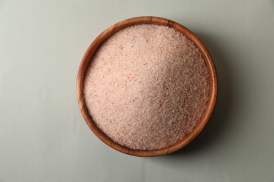 Photo of Himalayan salt in bowl on grey background, top view