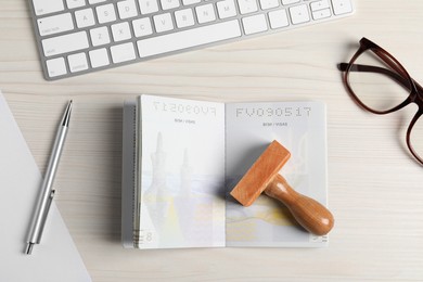 Ukraine, Lviv - September 6, 2022: Passport, visa stamp and pen with keyboard on white wooden table, flat lay