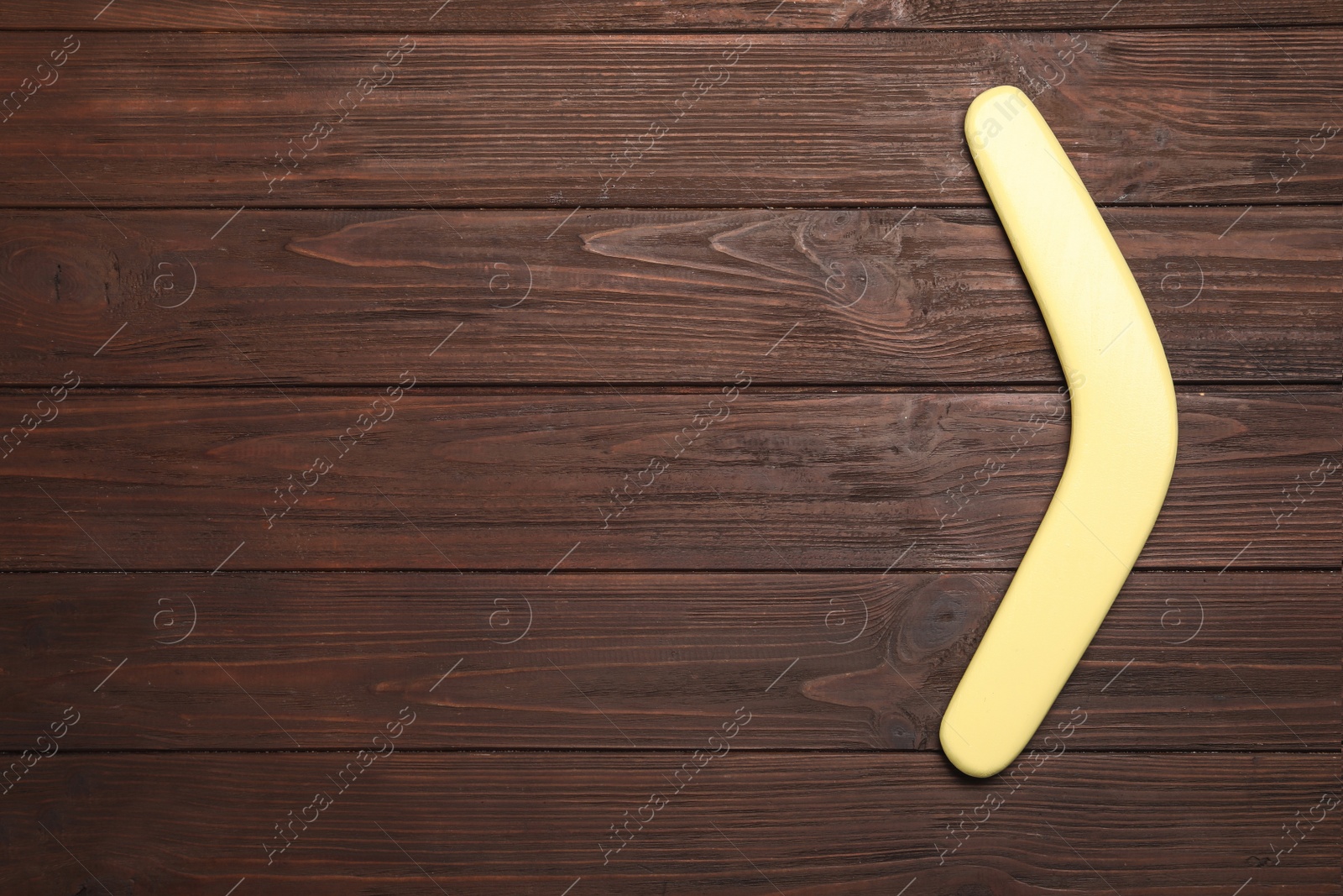 Photo of Boomerang on wooden background, top view. Space for text