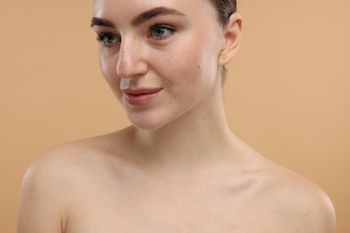 Portrait of beautiful woman on beige background, closeup