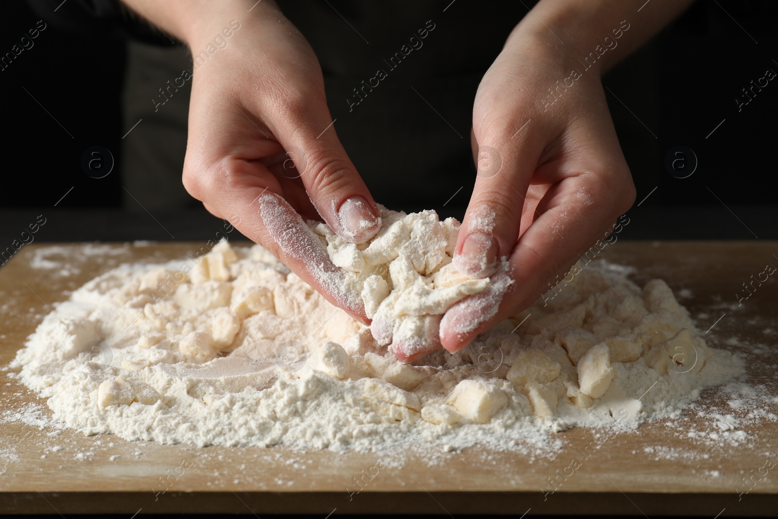 Photo of Woman making shortcrust pastry at table, closeup