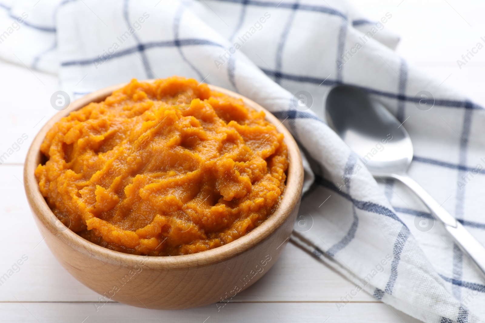 Photo of Bowl with tasty puree on white wooden table, closeup