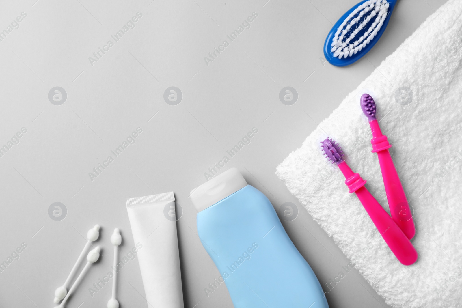 Photo of Flat lay composition with baby toothbrushes, toiletries and space for text on color background