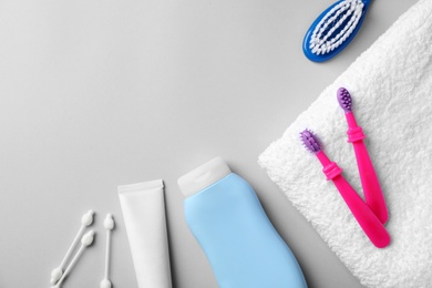 Photo of Flat lay composition with baby toothbrushes, toiletries and space for text on color background