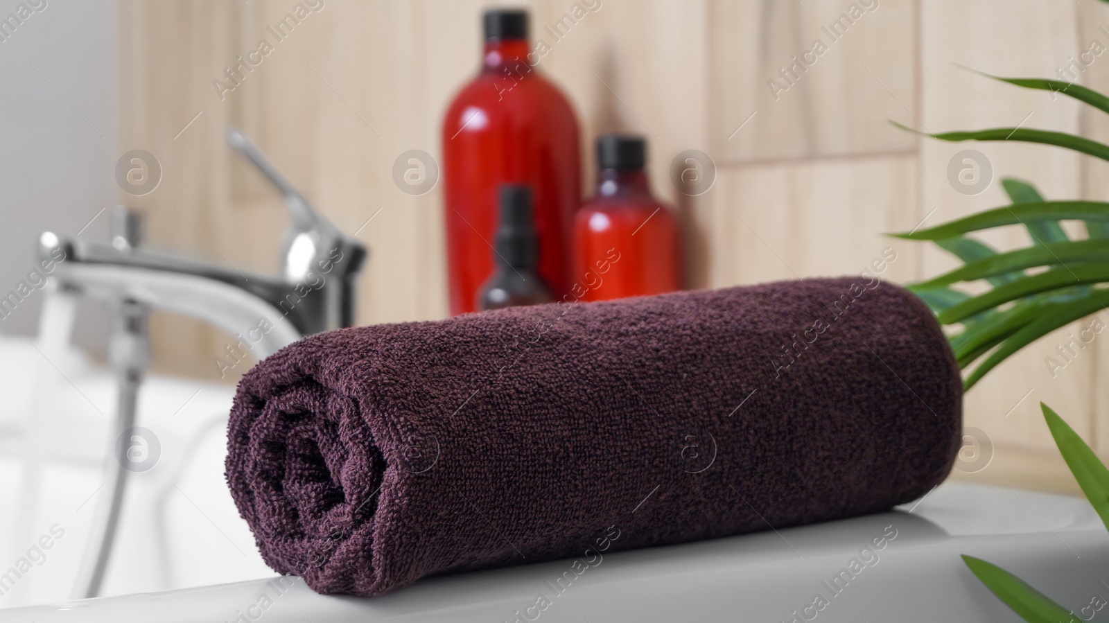 Photo of Rolled bath towel on tub in bathroom