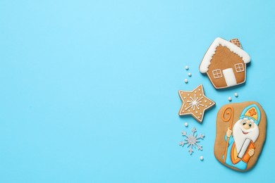 Tasty gingerbread cookies on light blue background, flat lay with space for text. St. Nicholas Day celebration