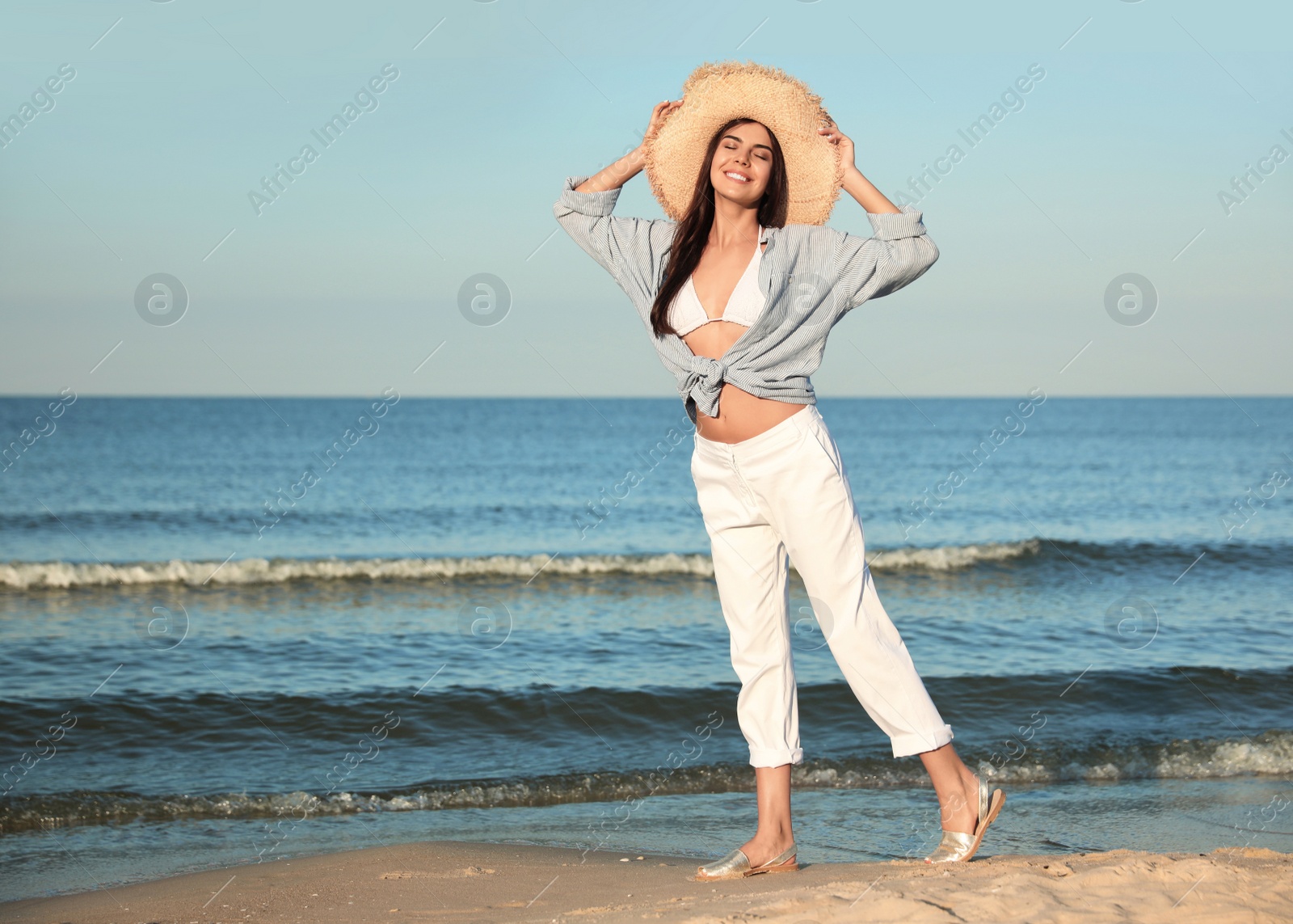 Photo of Beautiful young woman in straw hat on beach