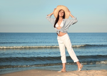 Photo of Beautiful young woman in straw hat on beach