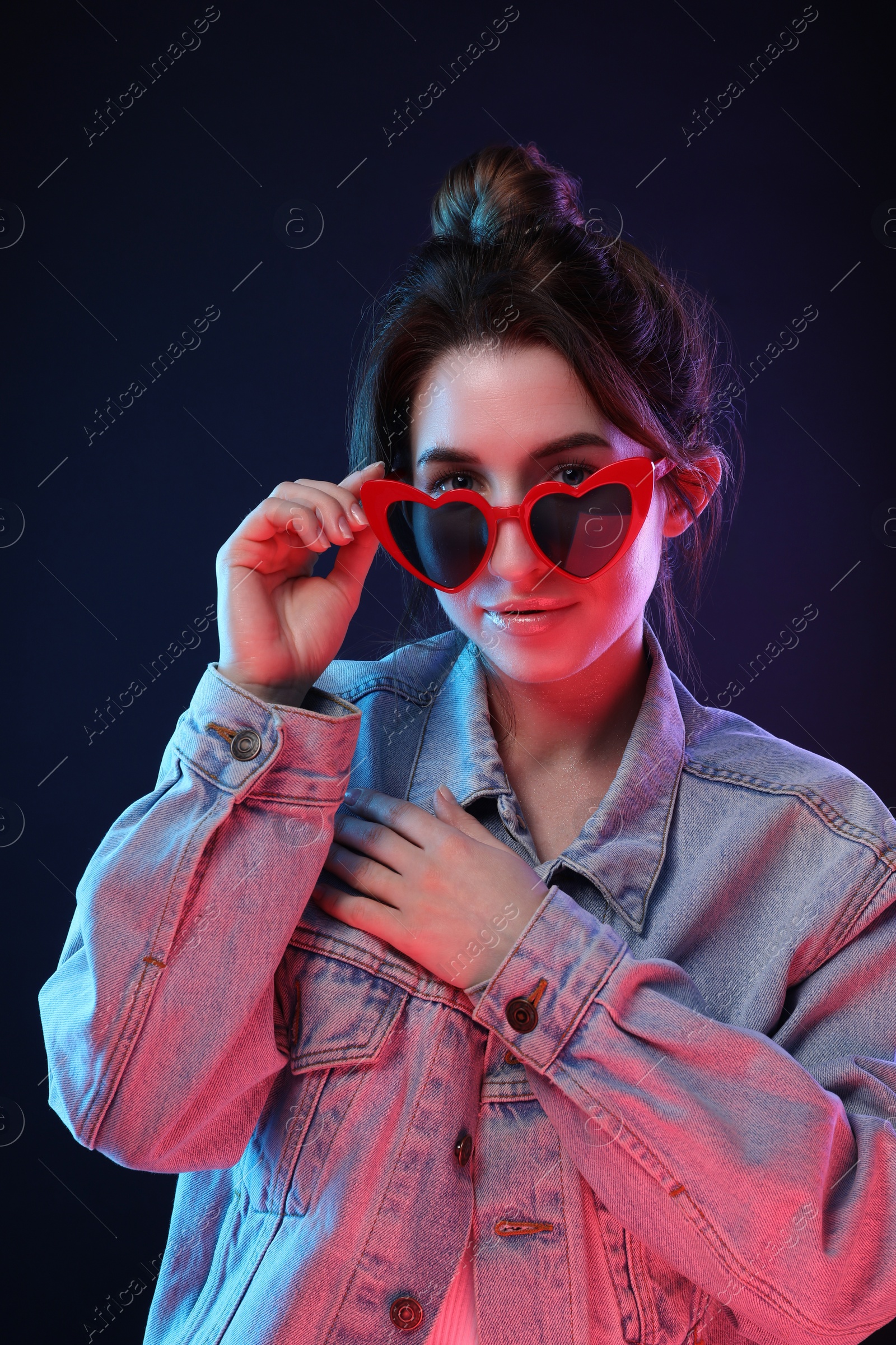 Photo of Portrait of young woman in sunglasses on color background