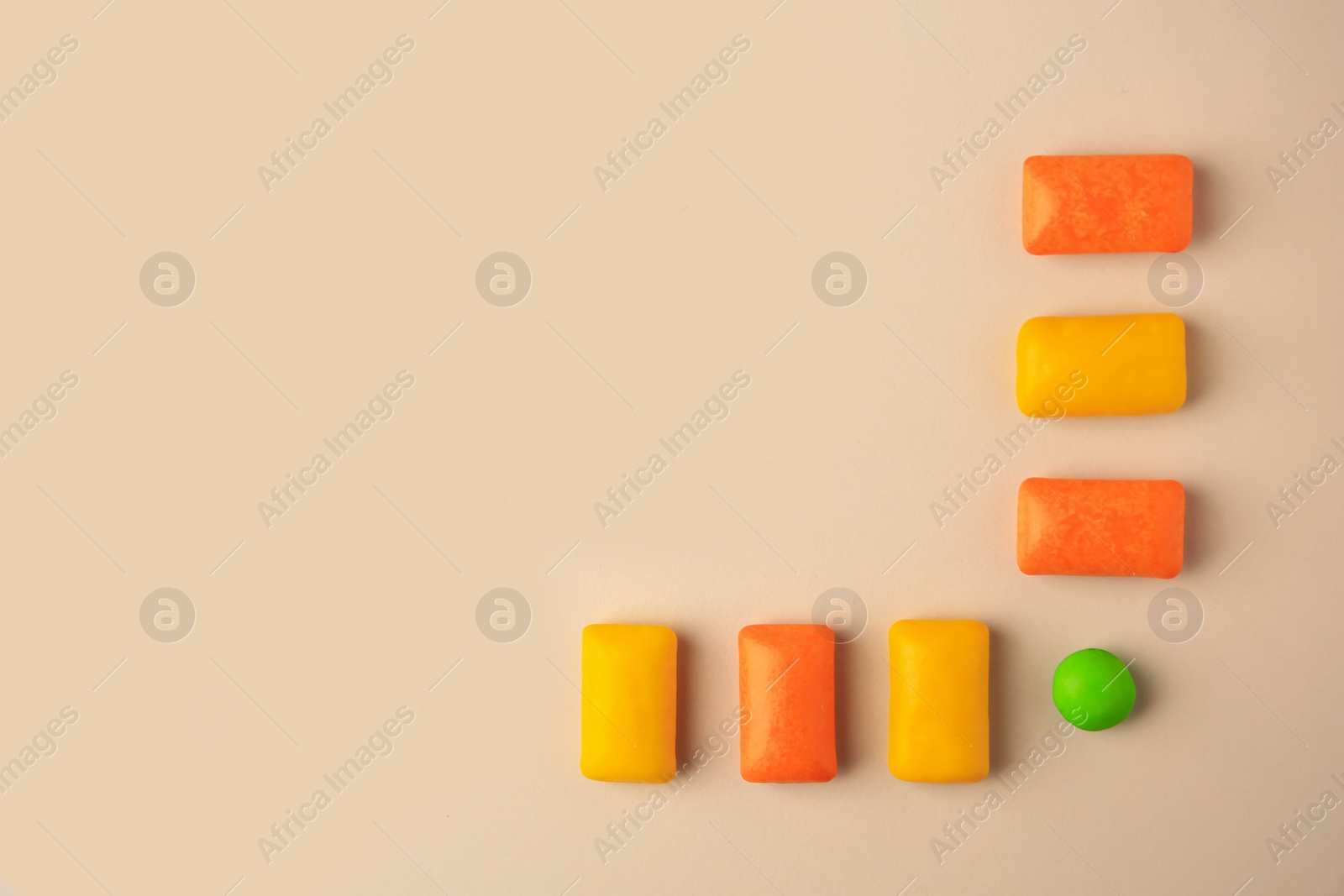 Photo of Tasty chewing gums on beige background, flat lay. Space for text