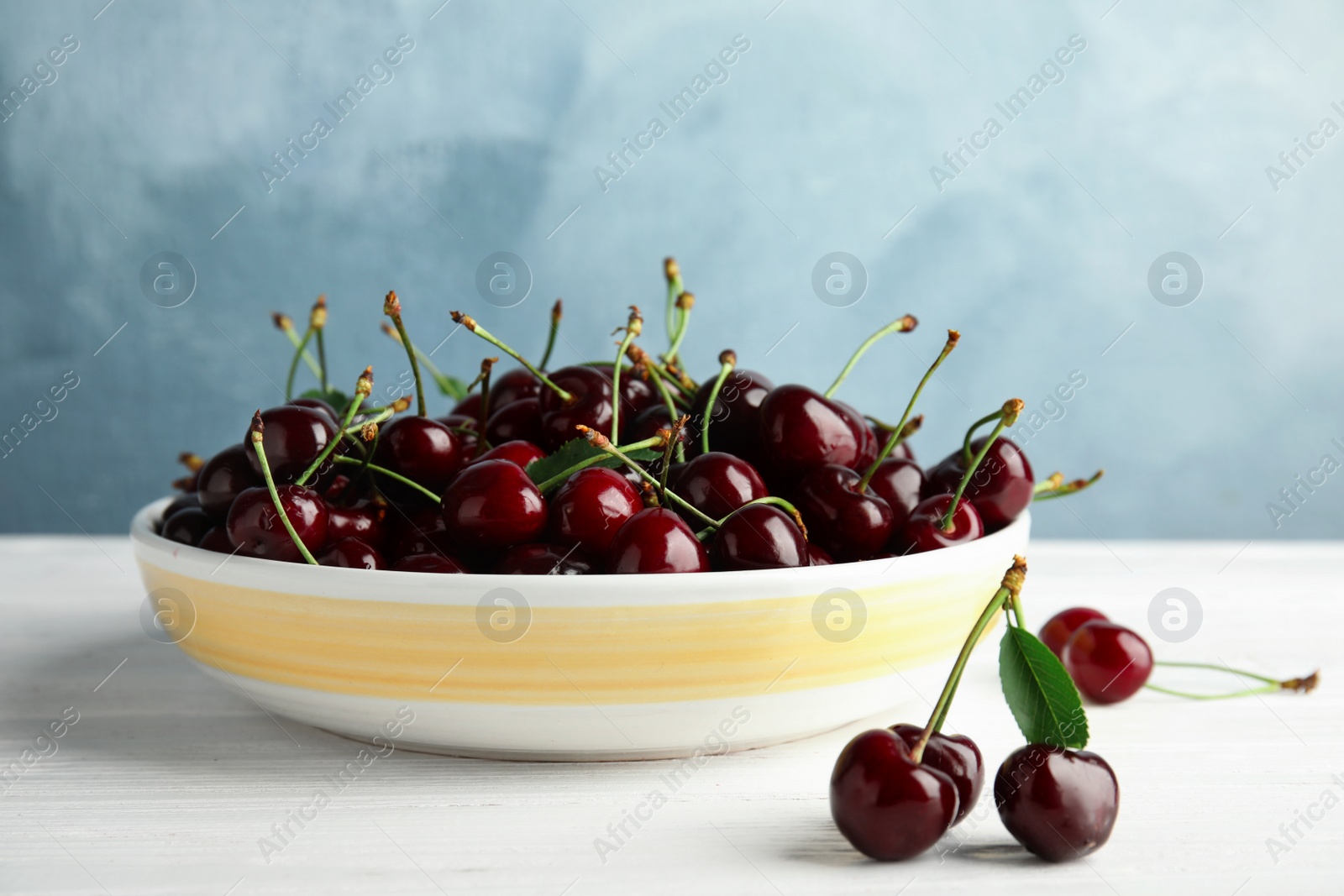 Photo of Plate with sweet red cherries on wooden table