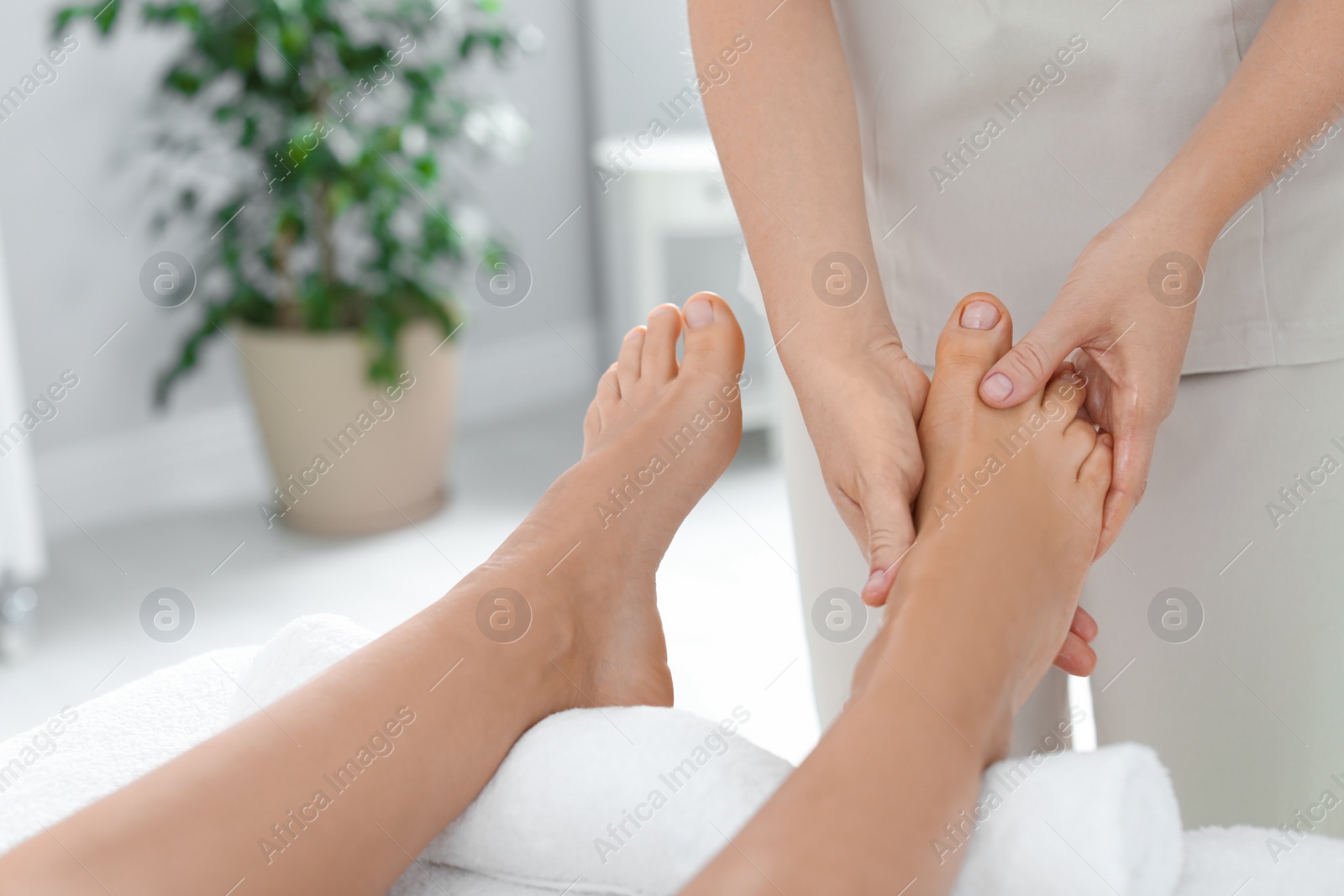 Photo of Woman receiving foot massage in wellness center, closeup