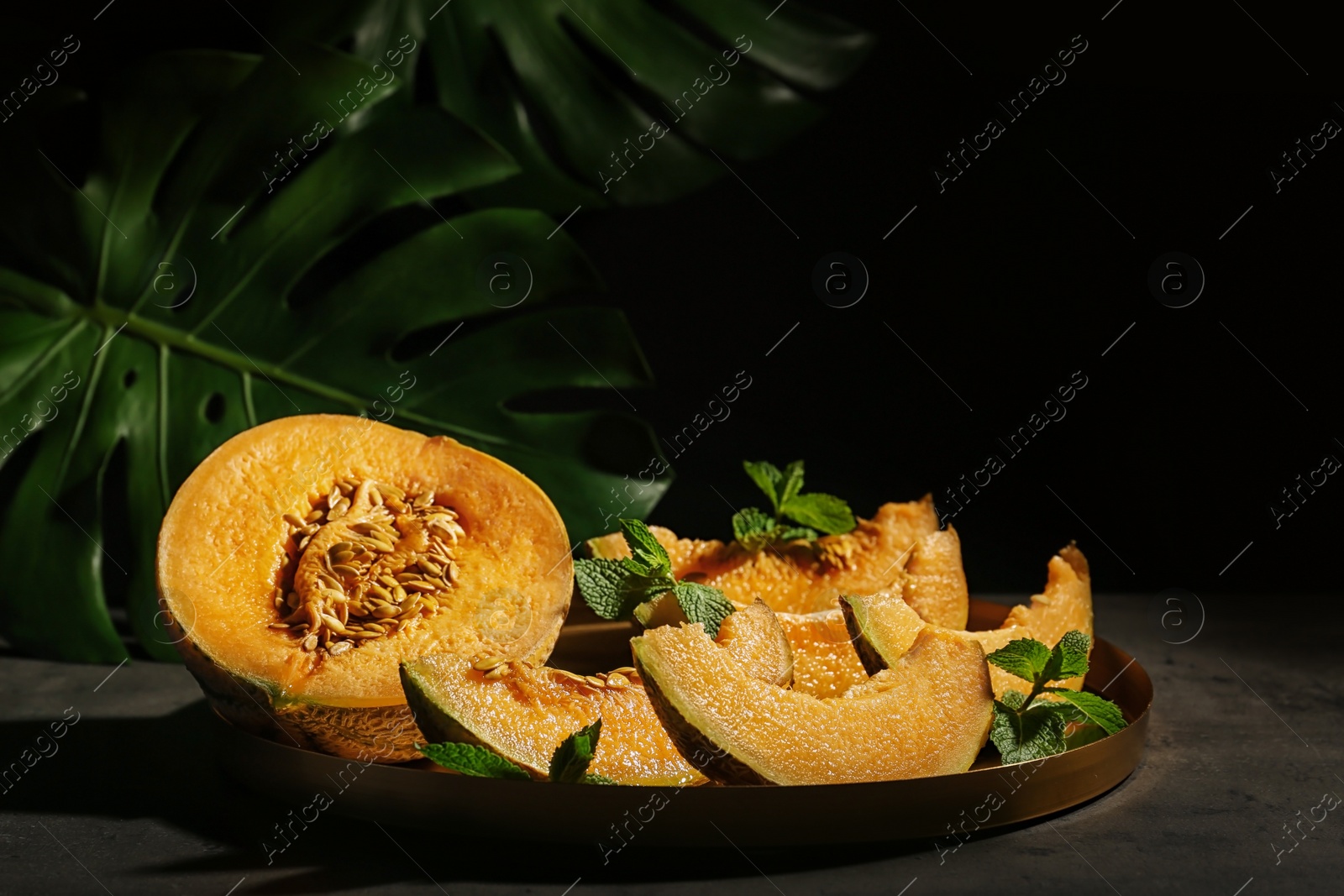 Photo of Freshly sliced ripe melon on table against black background