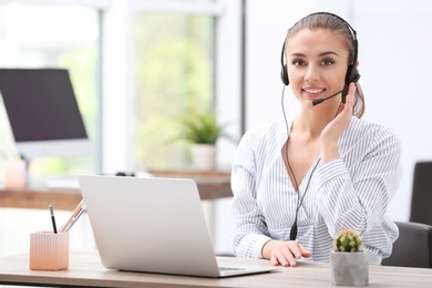 Photo of Female receptionist with headset at desk in office