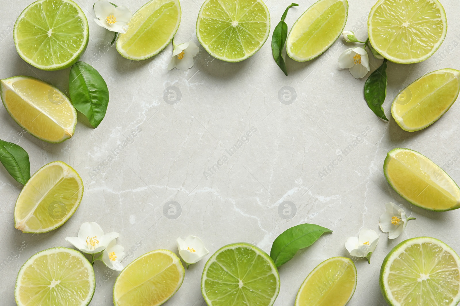 Photo of Frame made of fresh ripe limes on light background, top view