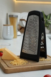 Photo of Grater and delicious cheese on kitchen counter