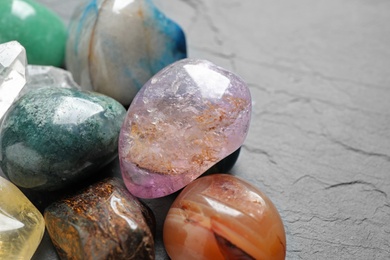 Photo of Different beautiful gemstones on grey background, closeup