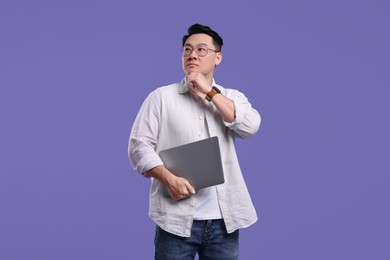 Photo of Thoughtful man with laptop on lilac background, space for text