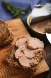 Photo of Fresh bread with delicious meat pate on wooden table, closeup
