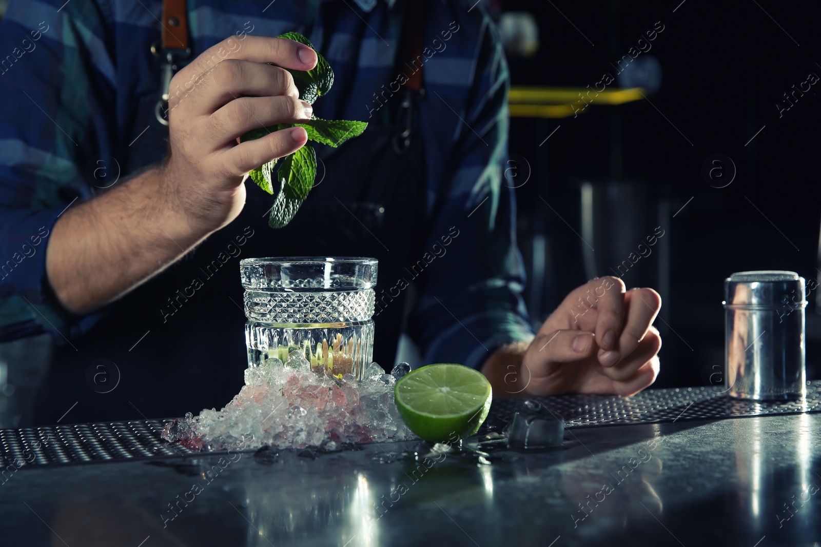 Photo of Barman making Mojito cocktail at counter in pub, closeup. Space for text