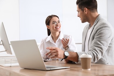 Businessman helping intern with work in office