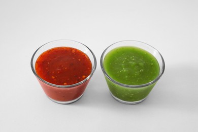 Photo of Bowls with delicious salsa sauces on white background