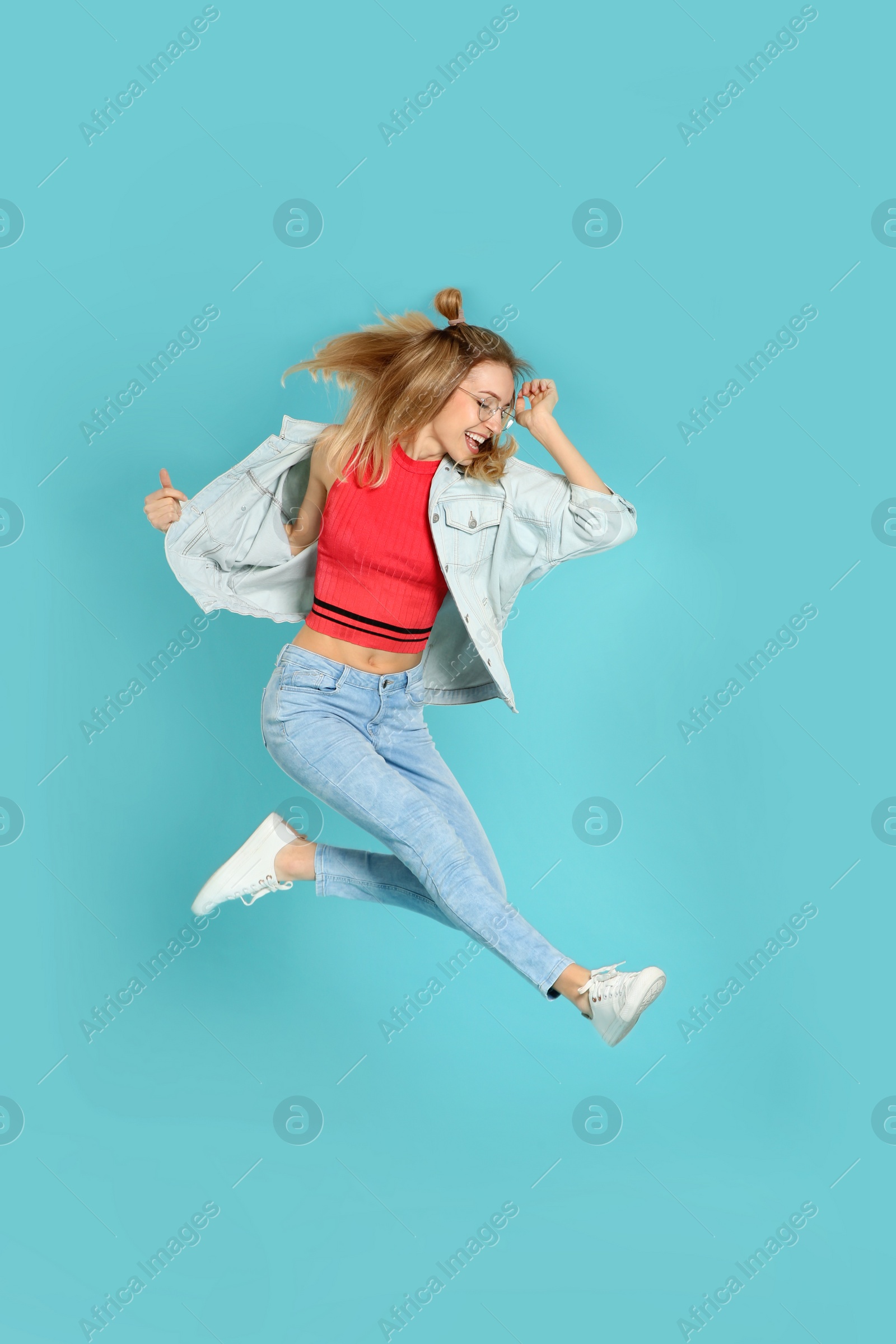 Photo of Full length portrait of emotional woman jumping on color background