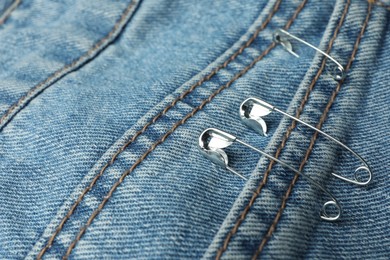 Photo of Closeup view of metal safety pins on clothing